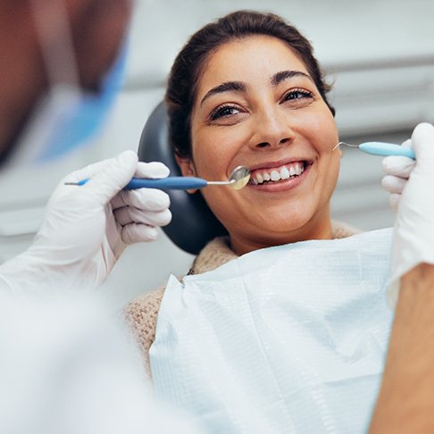 Woman in dentist’s chair undergoing dental cleaning