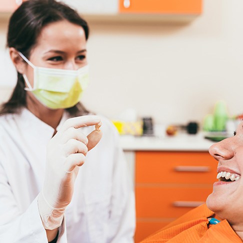 A dentist holding a patient’s extracted tooth 