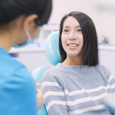 Woman smiling at dentist during dental checkup and teeth cleaning