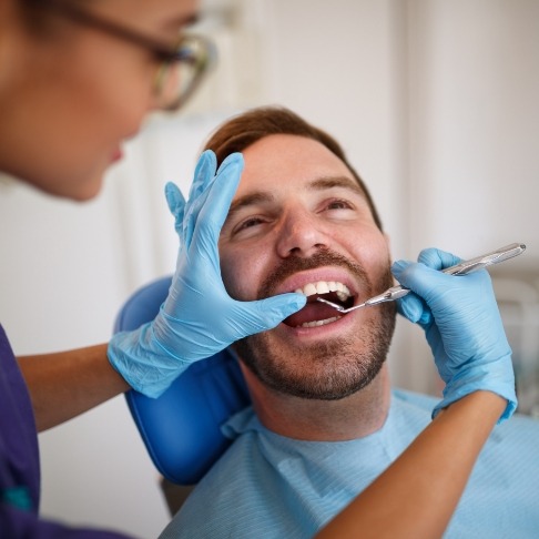 Dentist performing oral cancer screening
